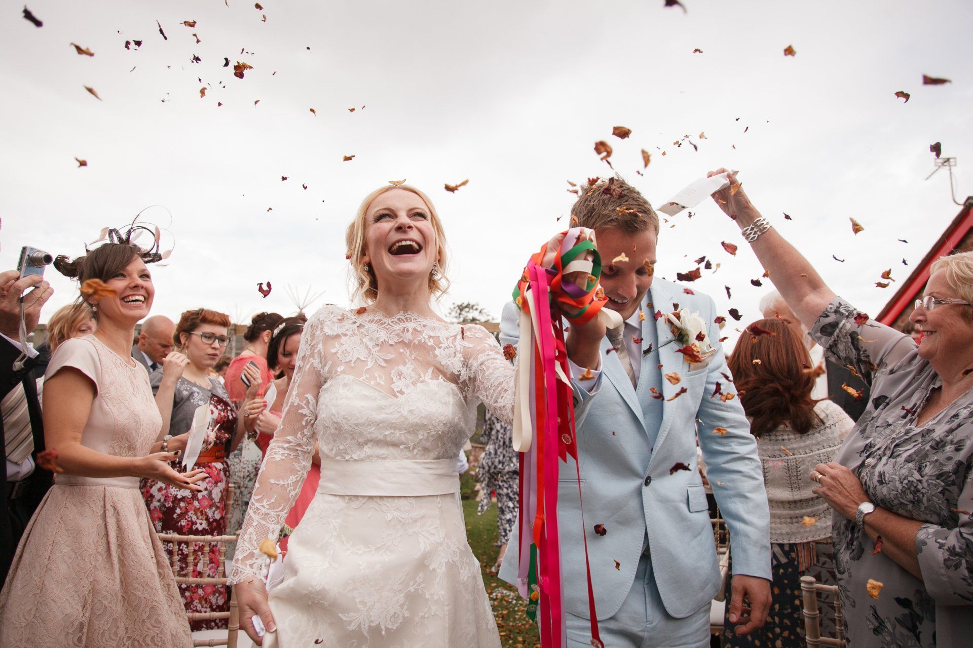 Wedding ceremony in garden confetti thrown over couple
