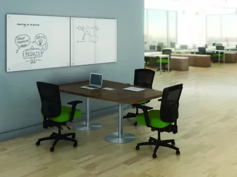 Open office plan featuring desks, chairs, and whiteboards for collaboration.