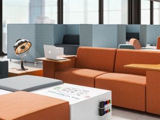 A living room filled with furniture and a table with a laptop on it.