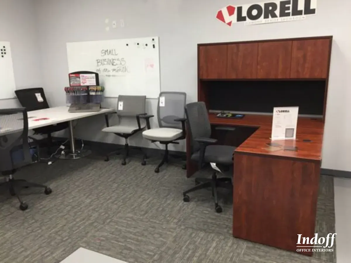 Modern office desks and chairs displayed in a showroom.