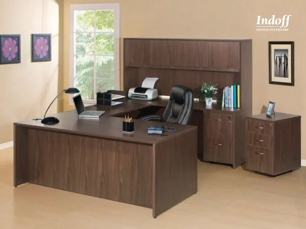 A wooden desk with a chair and a printer in an office.