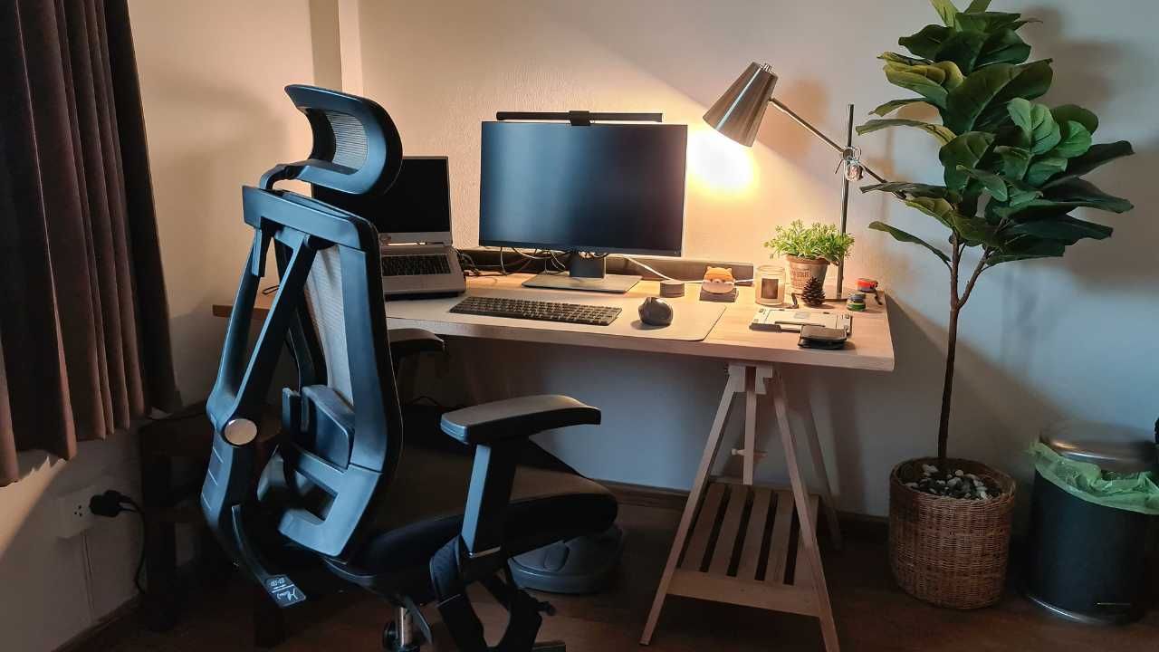 A desk with a computer and a chair in a room.