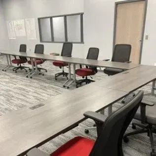 A conference room with a long table and chairs.