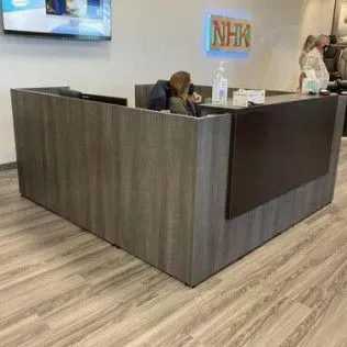 A woman is sitting at a desk in a reception area.