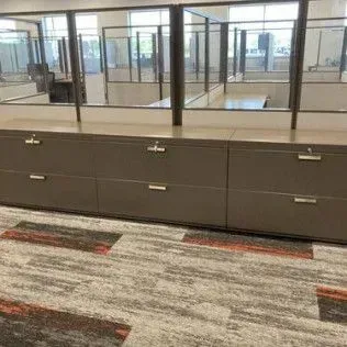 A row of filing cabinets in a cubicle in an office.