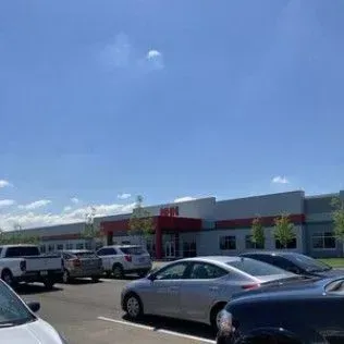 A lot of cars are parked in front of a building.