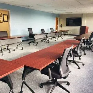 There are many tables and chairs in the room.