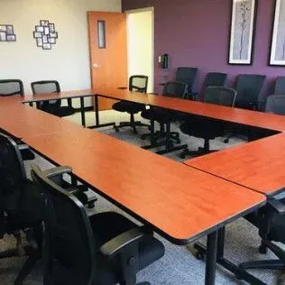 A conference room with tables and chairs and purple walls.