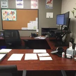 A office with a desk , chairs , computers and a sign that says parking only