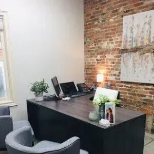 There is a brick wall in the background of the office.