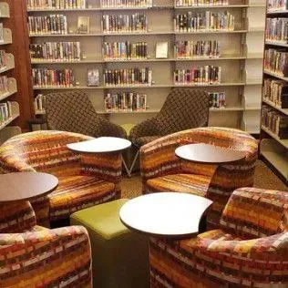 There are many chairs and tables in the library.