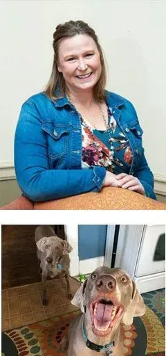 A woman is sitting at a table next to a dog.