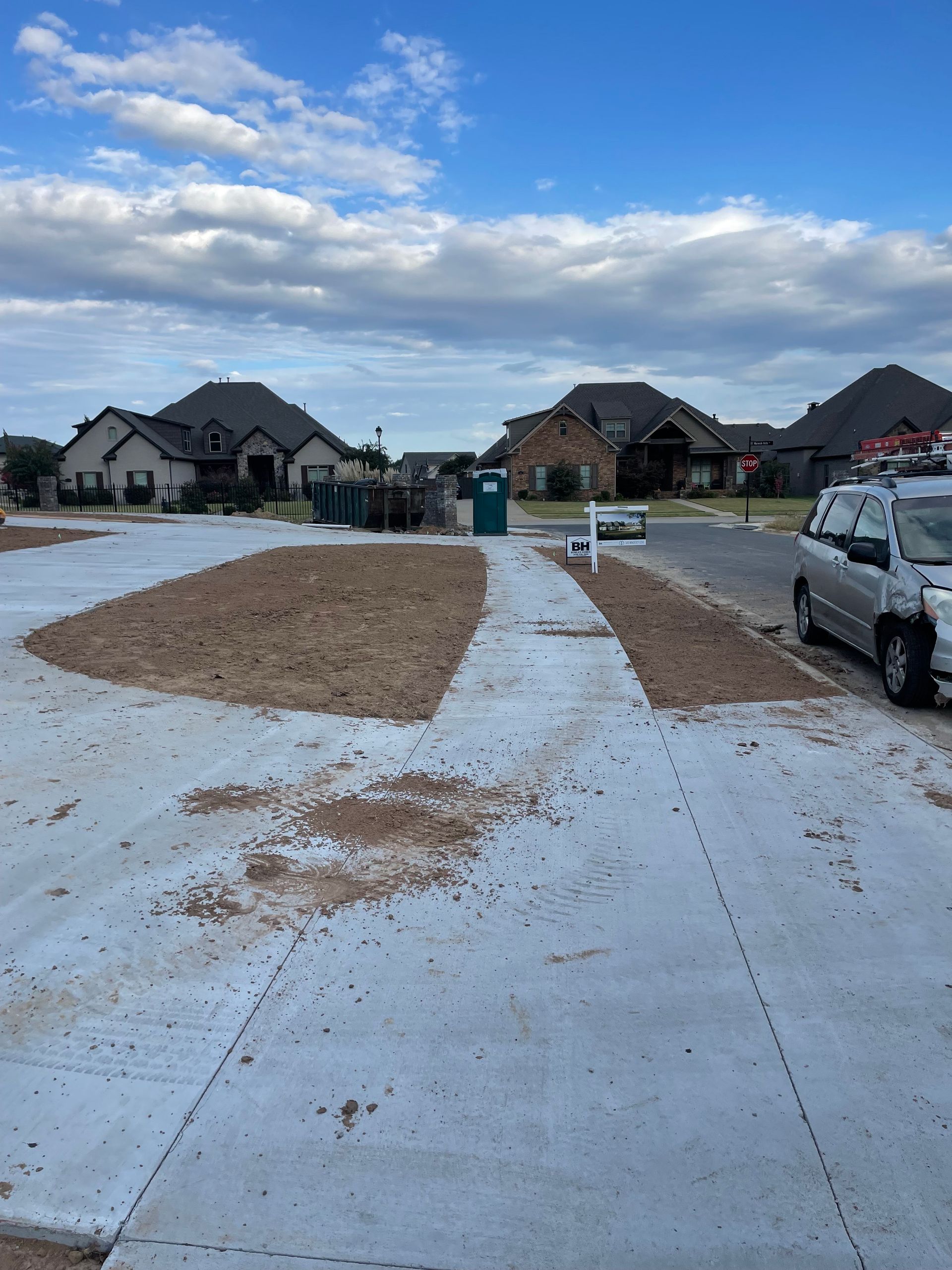 A white van is parked on the side of the road in a residential area
