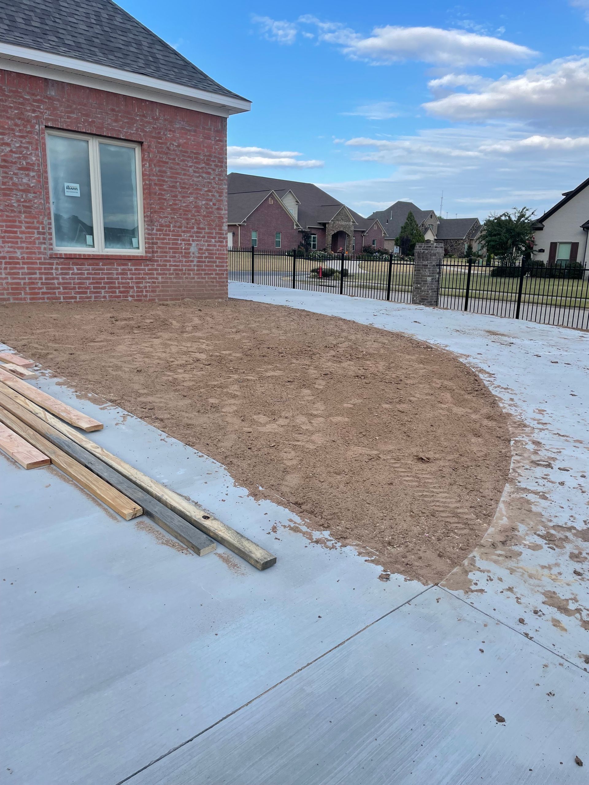 A brick house is being built in a residential area.