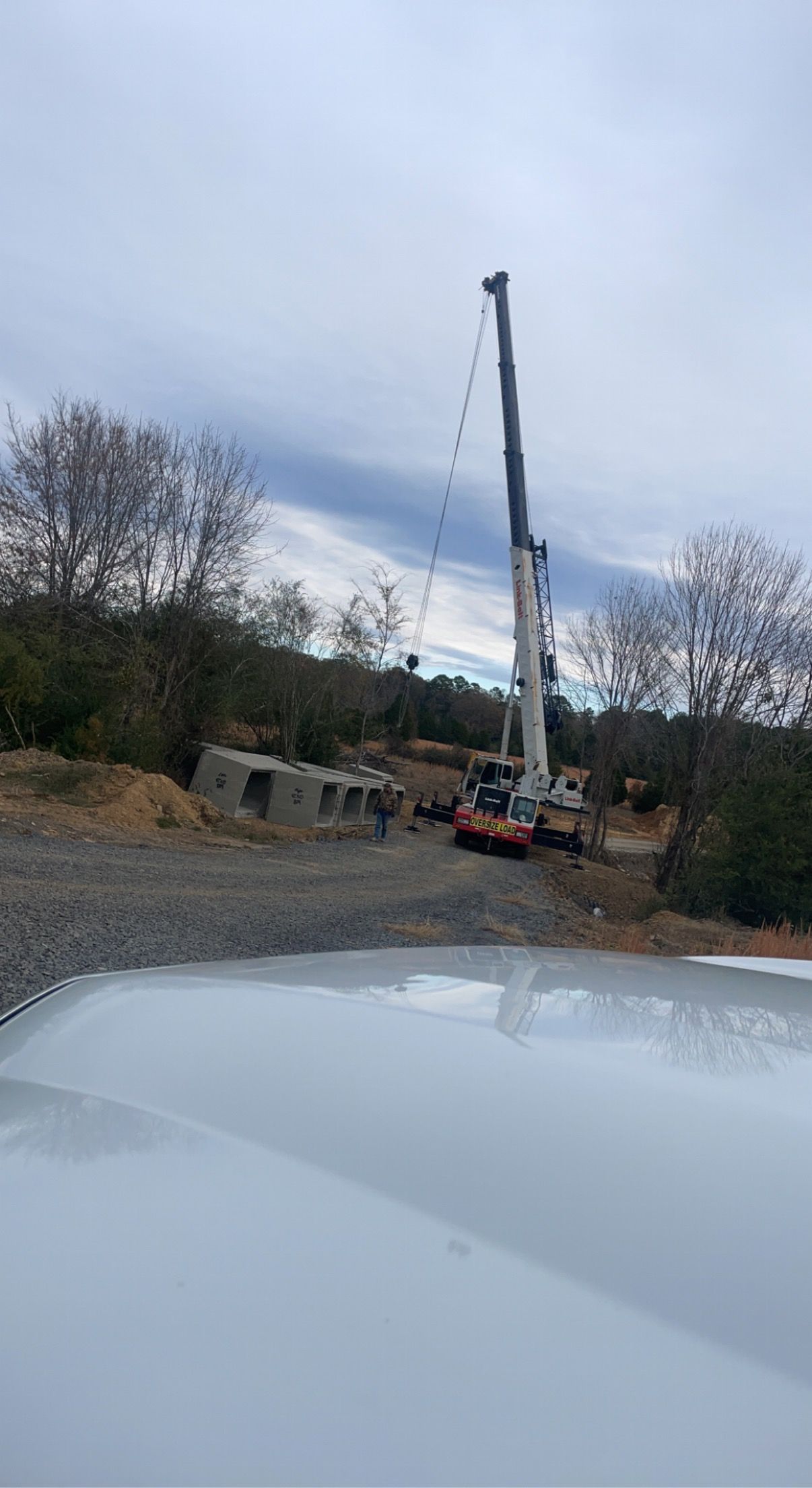 A large crane is sitting in the middle of a dirt field.