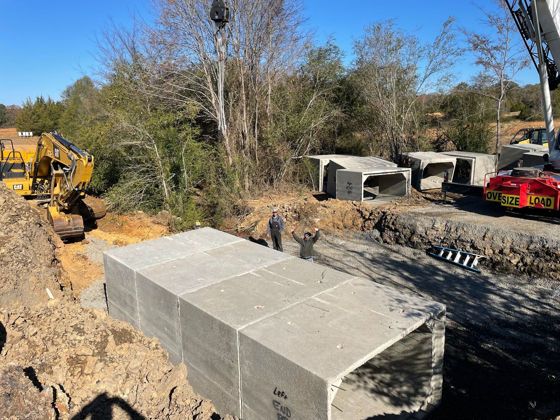 A crane is lifting a large concrete block on a construction site.