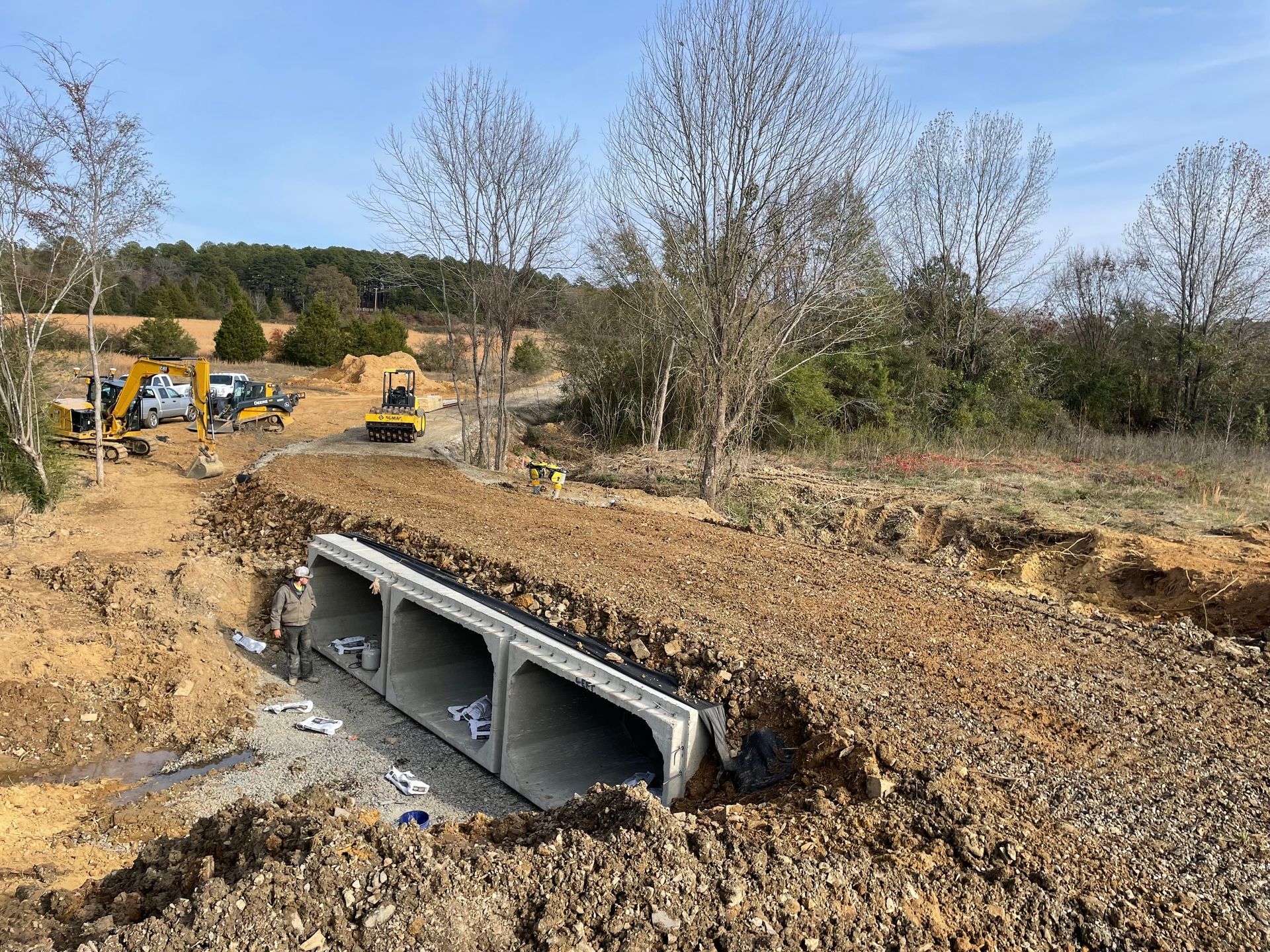 A construction site with a lot of dirt and trees in the background.