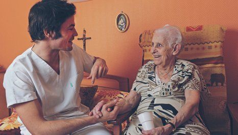 A carer interacting with the elderly woman