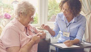 A carer taking care of an elderly woman