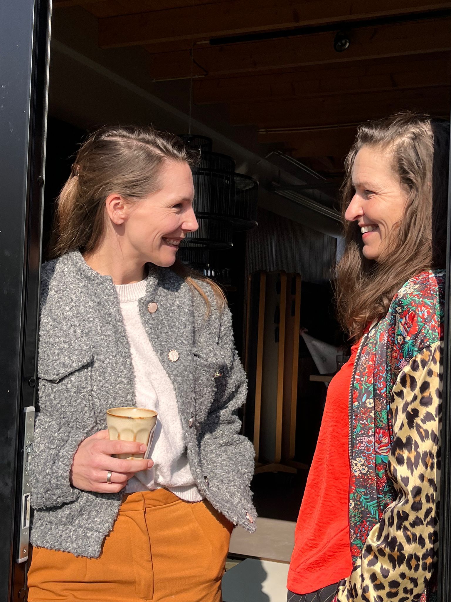 Twee vrouwen kijken elkaar lachend aan