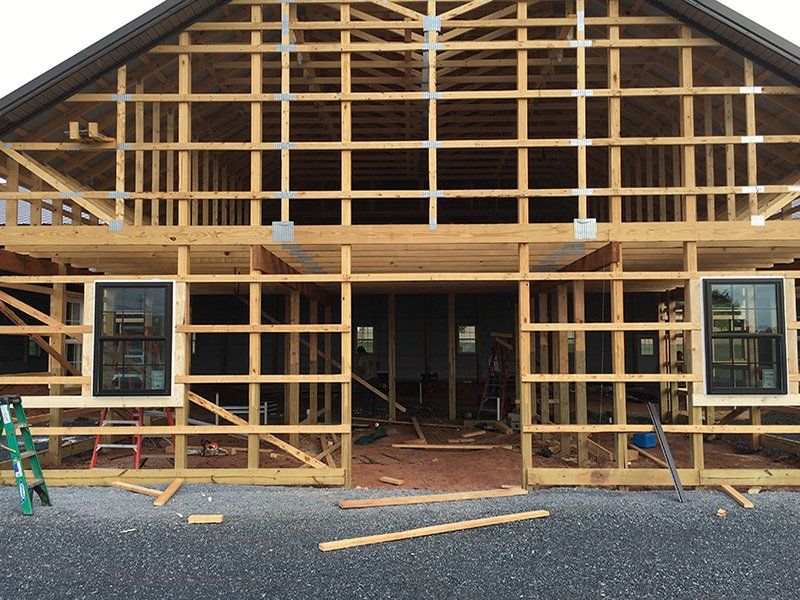 A house is being built with wooden beams and windows.