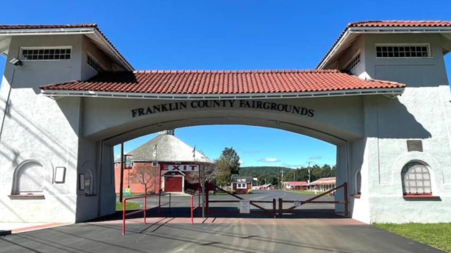 Entrance archway to Franklin County Fairgrounds under a red roof on a sunny day