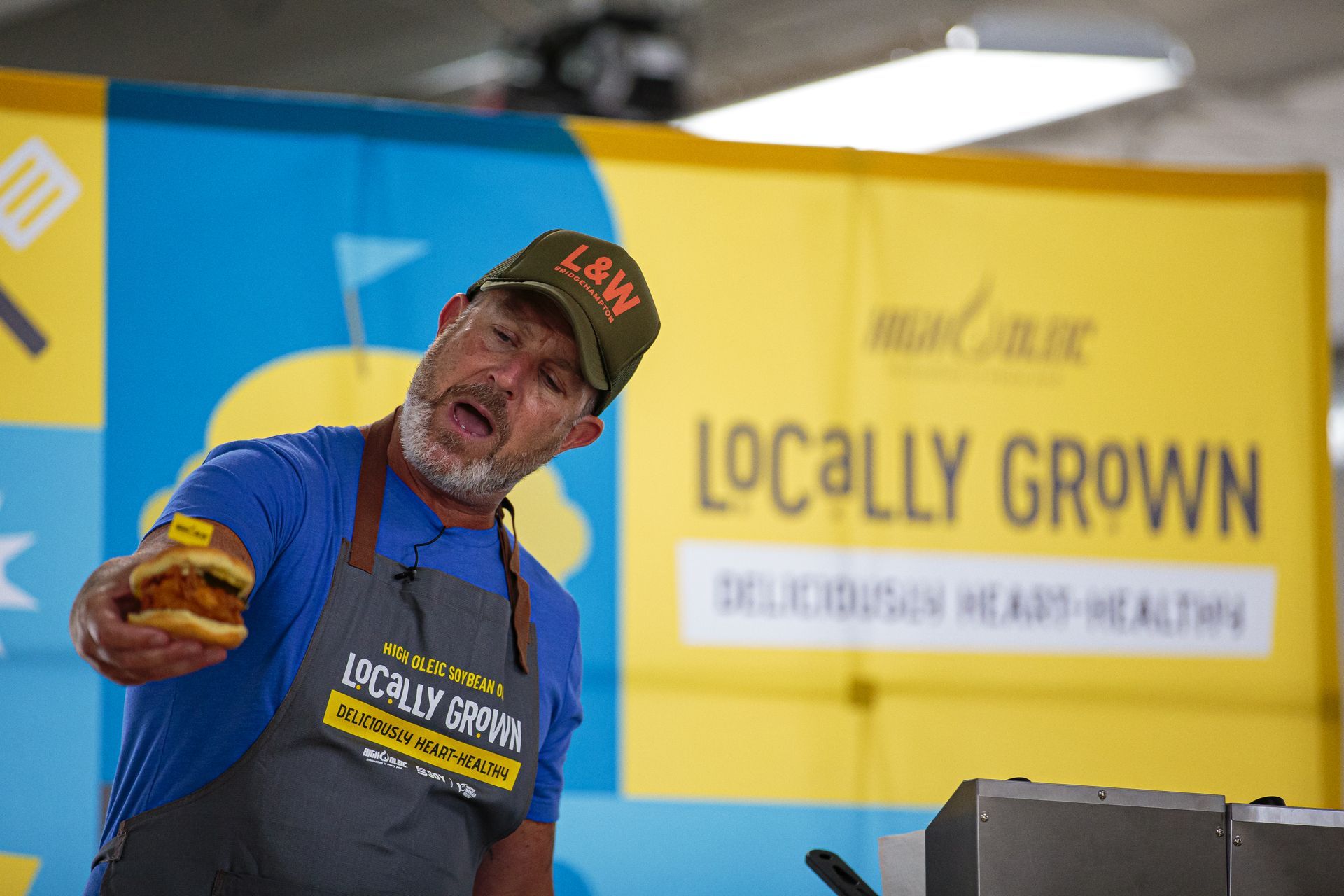 Man holding sandwich, looking excited at a 