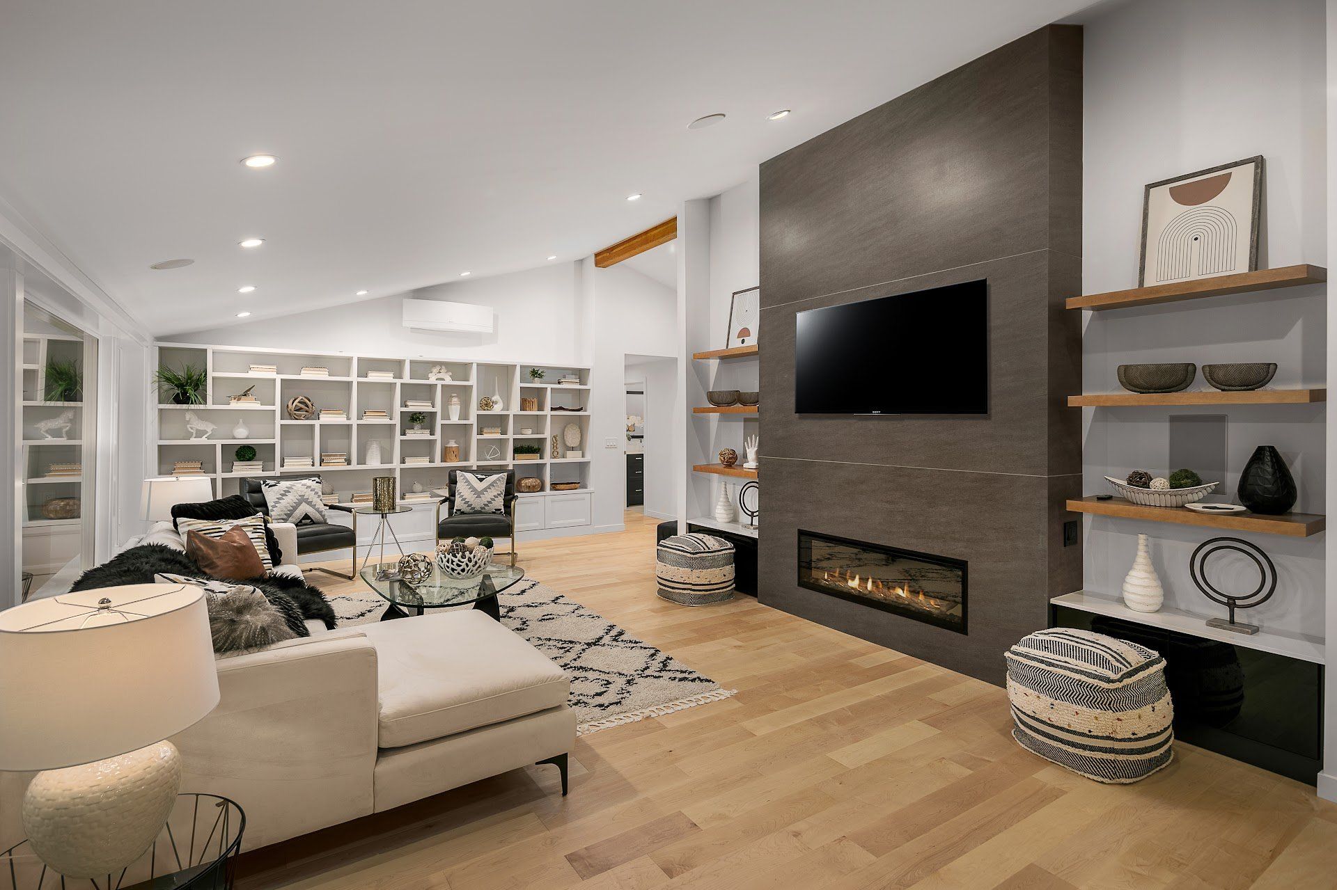 Modern living room with fireplace, built-in shelves, and hardwood floors.
