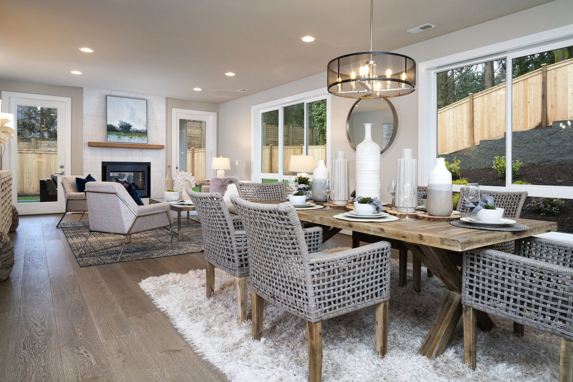 Dining room with wood table, woven chairs, and fireplace.