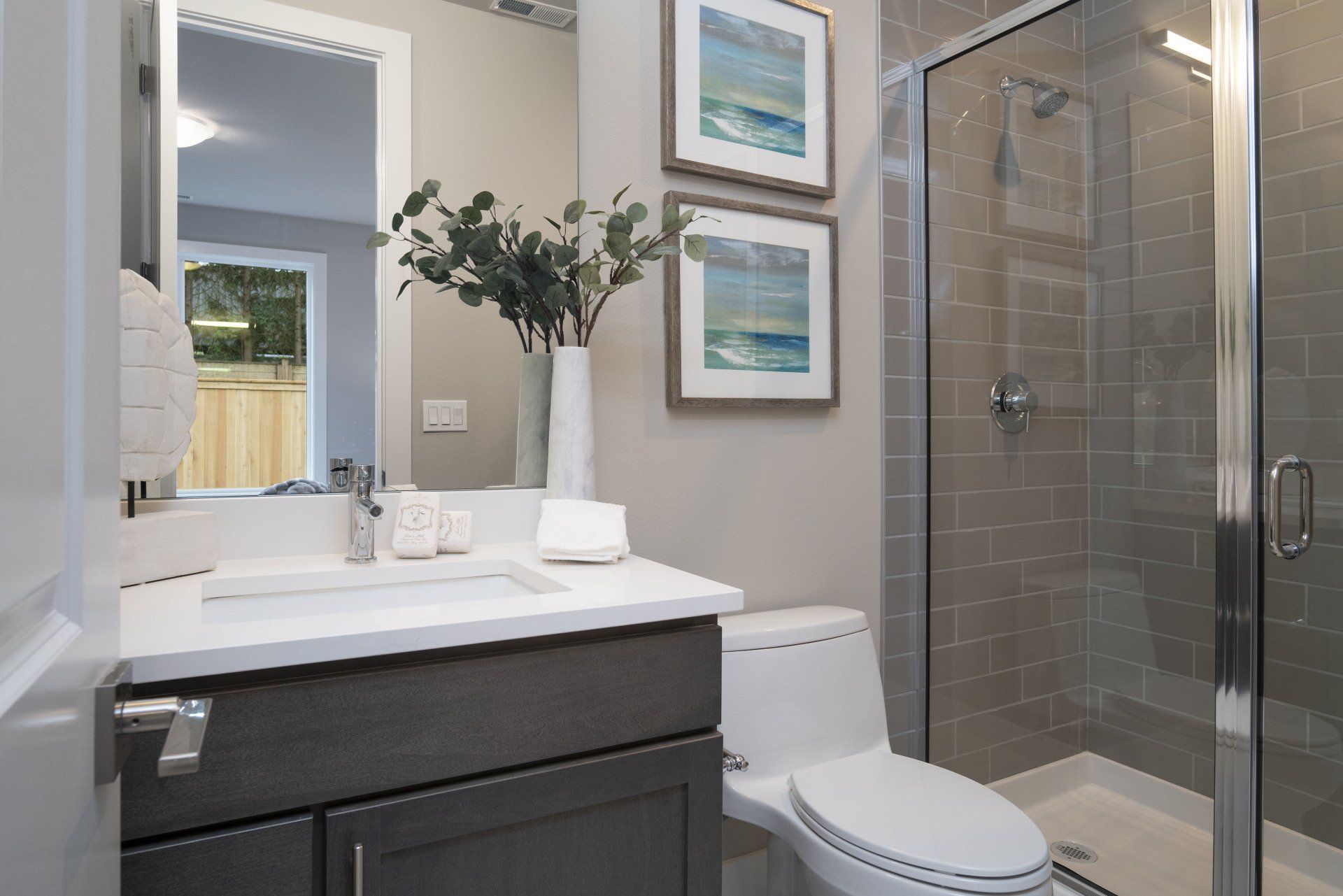 Modern bathroom with gray walls, a white vanity, and a glass shower.