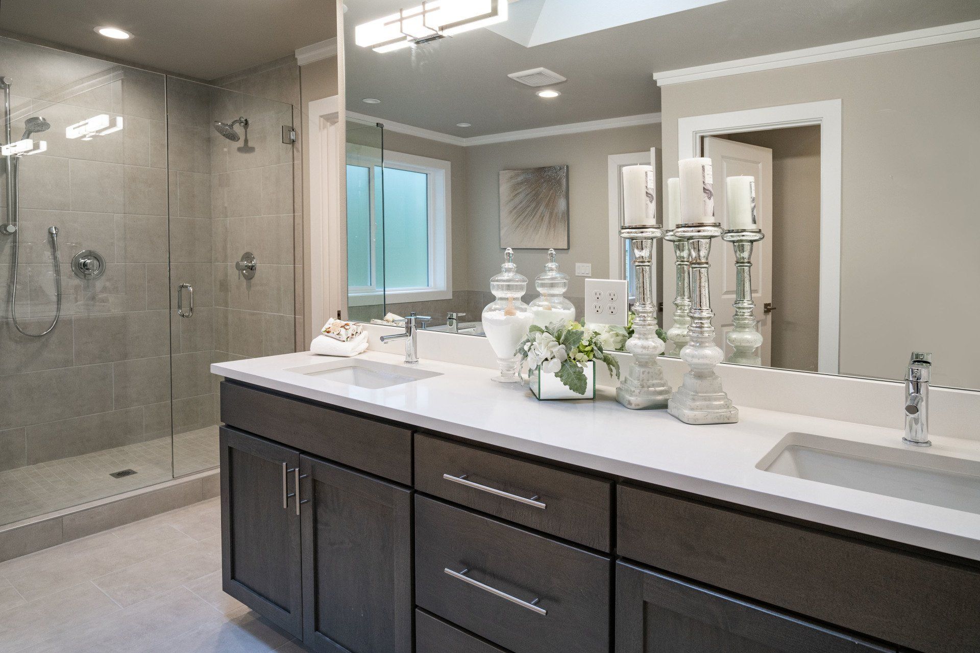 Modern bathroom with a double vanity, large mirror, and a walk-in shower.