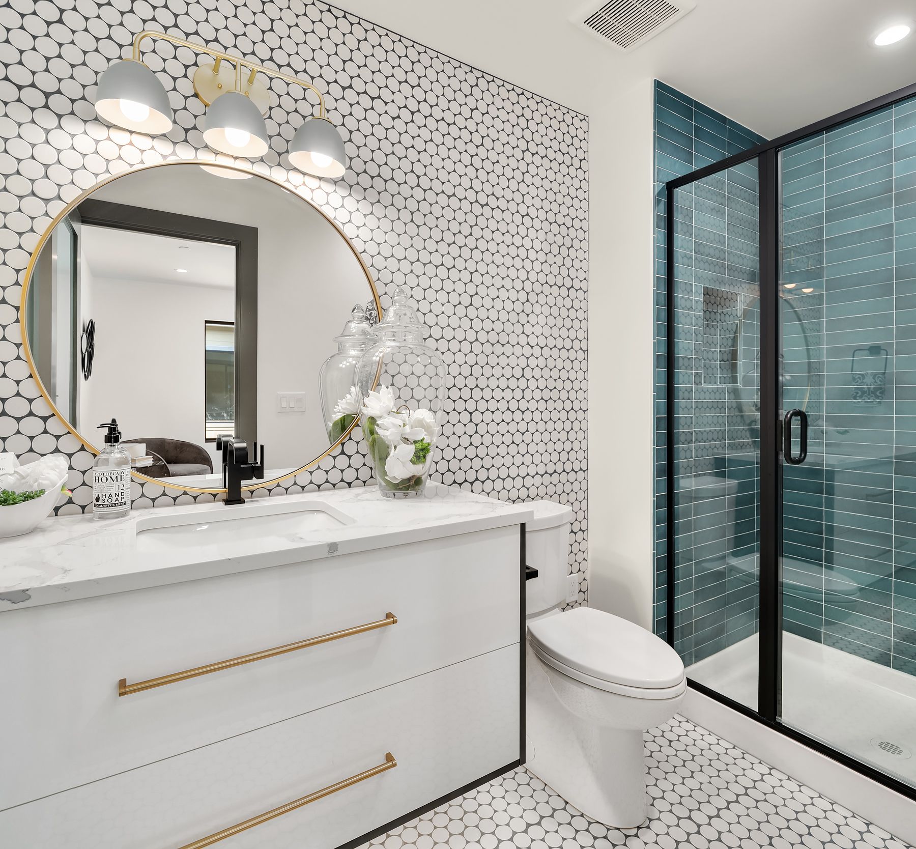 Modern bathroom with patterned white walls, marble countertop, black fixtures, and glass shower.
