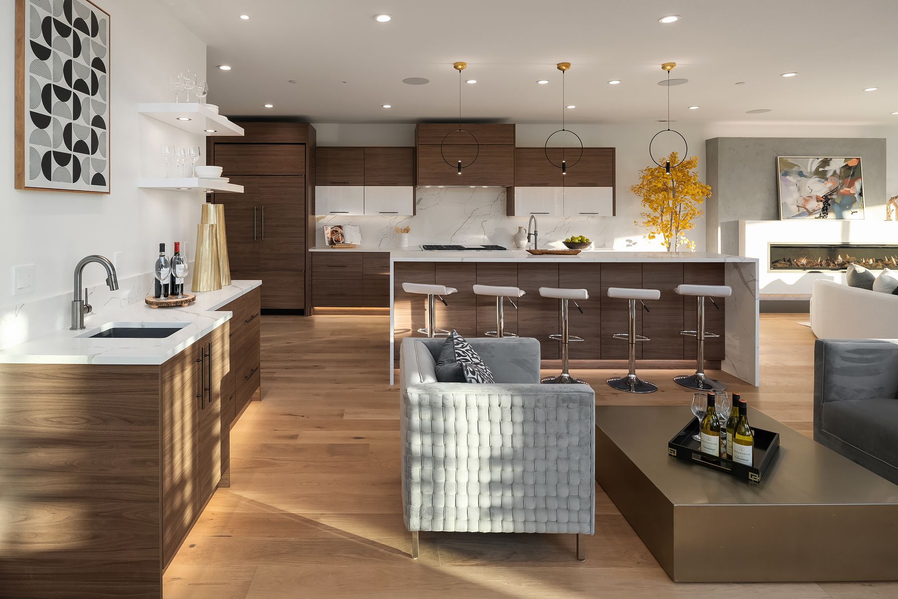 Modern kitchen and living space with a central island, wooden cabinetry, and a light-filled ambiance.