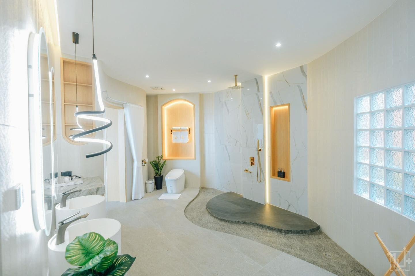 Modern bathroom with white walls, stone shower, curved layout, and unique lighting fixtures.