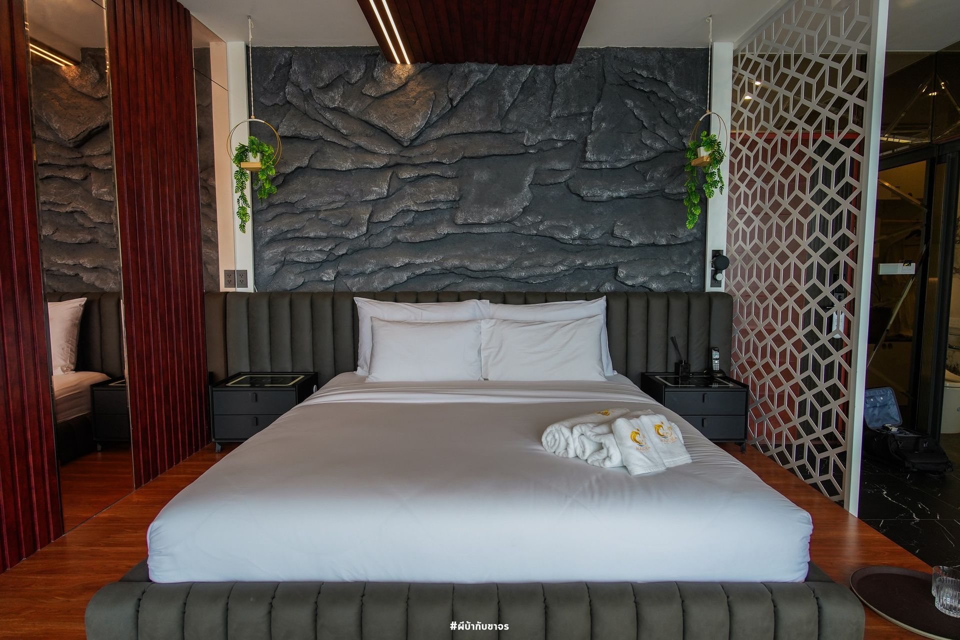Bedroom with a gray bed, textured wall, and red dividers.
