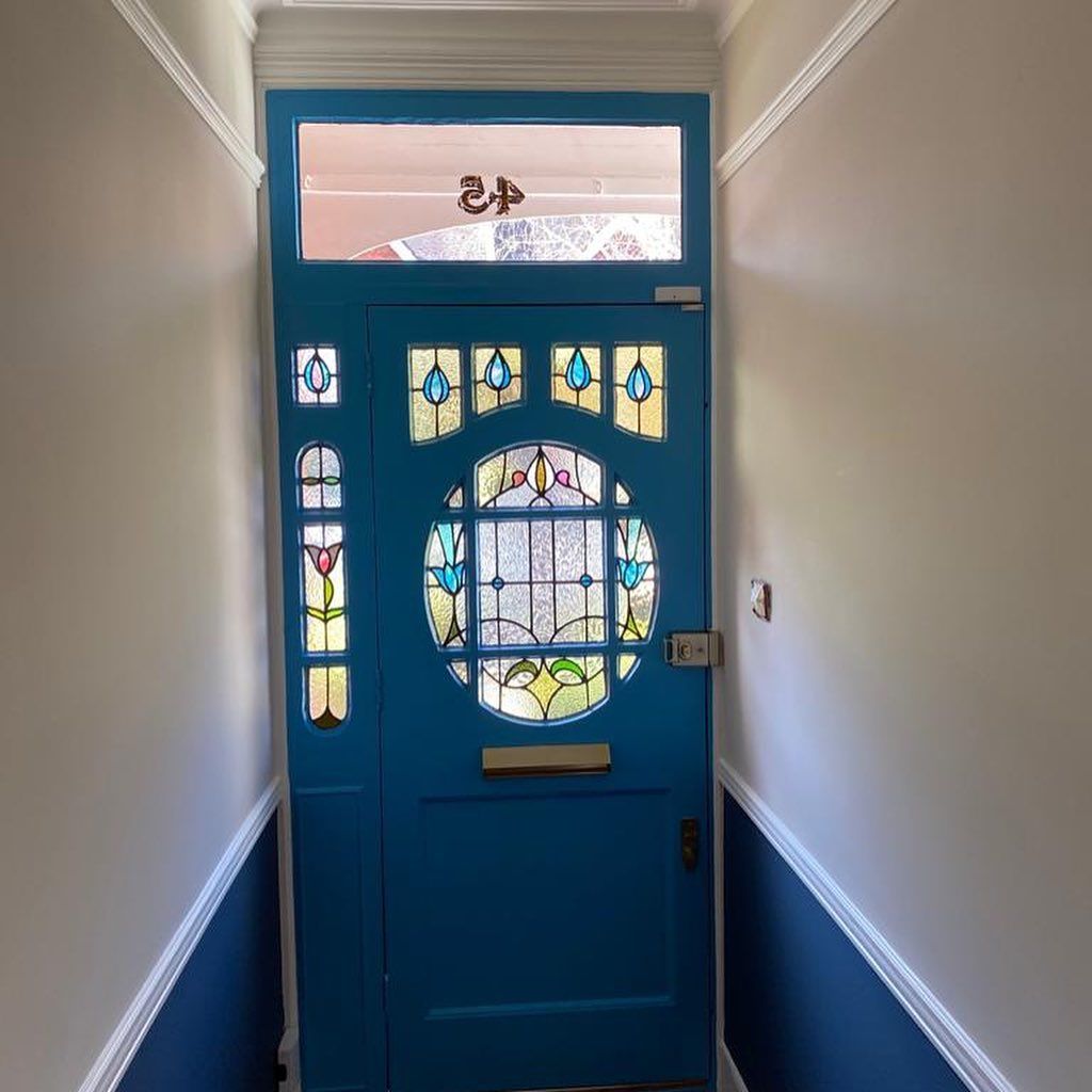 Blue front door with stained glass details and transom window.