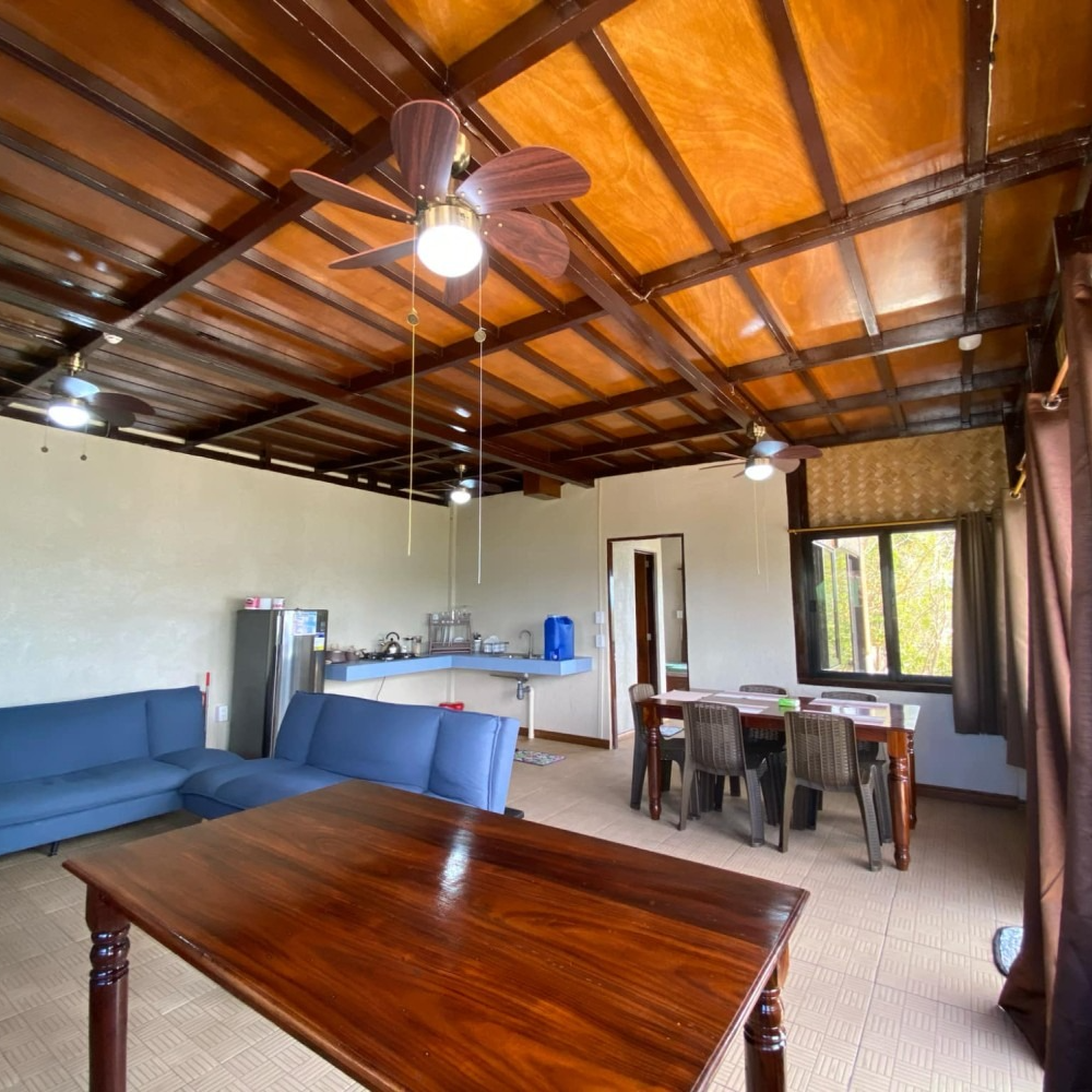 A living room with a table and chairs and a ceiling fan