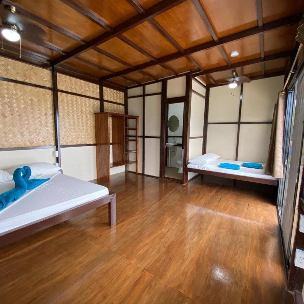 A bedroom with two beds and a ceiling fan