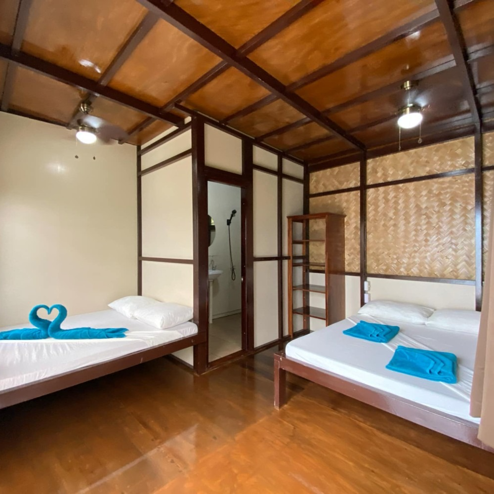 A bedroom with two beds and a ceiling fan