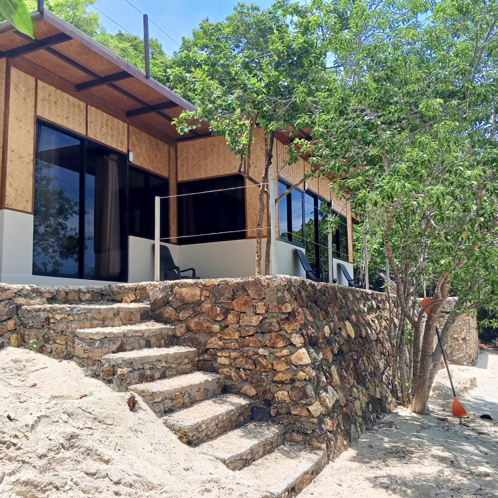 A house with a stone wall and stairs leading up to it