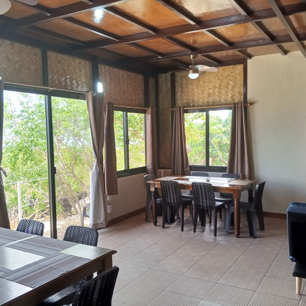 A dining room with tables and chairs and a ceiling fan