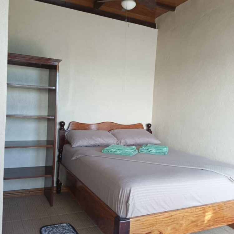 A bedroom with a bed and a ceiling fan