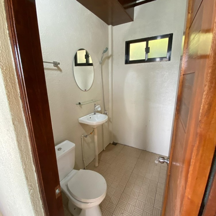 A bathroom with a toilet a sink and a mirror
