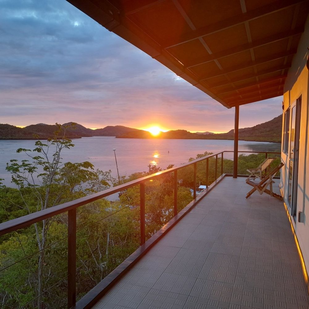 A balcony overlooking a body of water at sunset