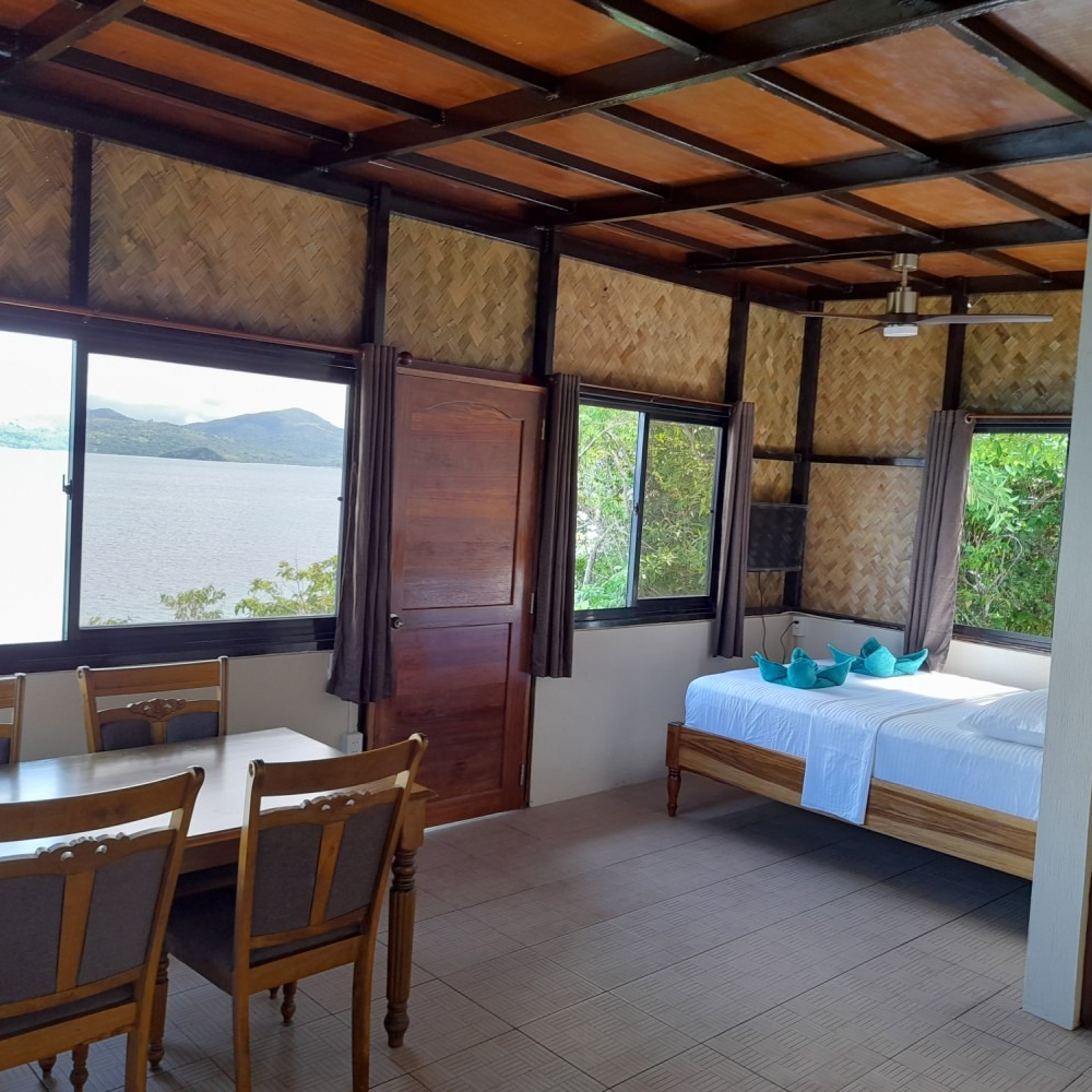 A bedroom with a table and chairs and a bed