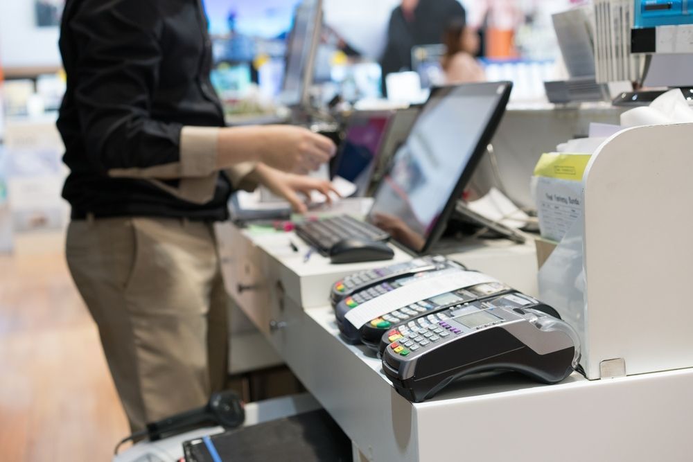 A Woman Is Working At A Cash Register In A Store — Coastal Registers & POS In Ruthven, NSW