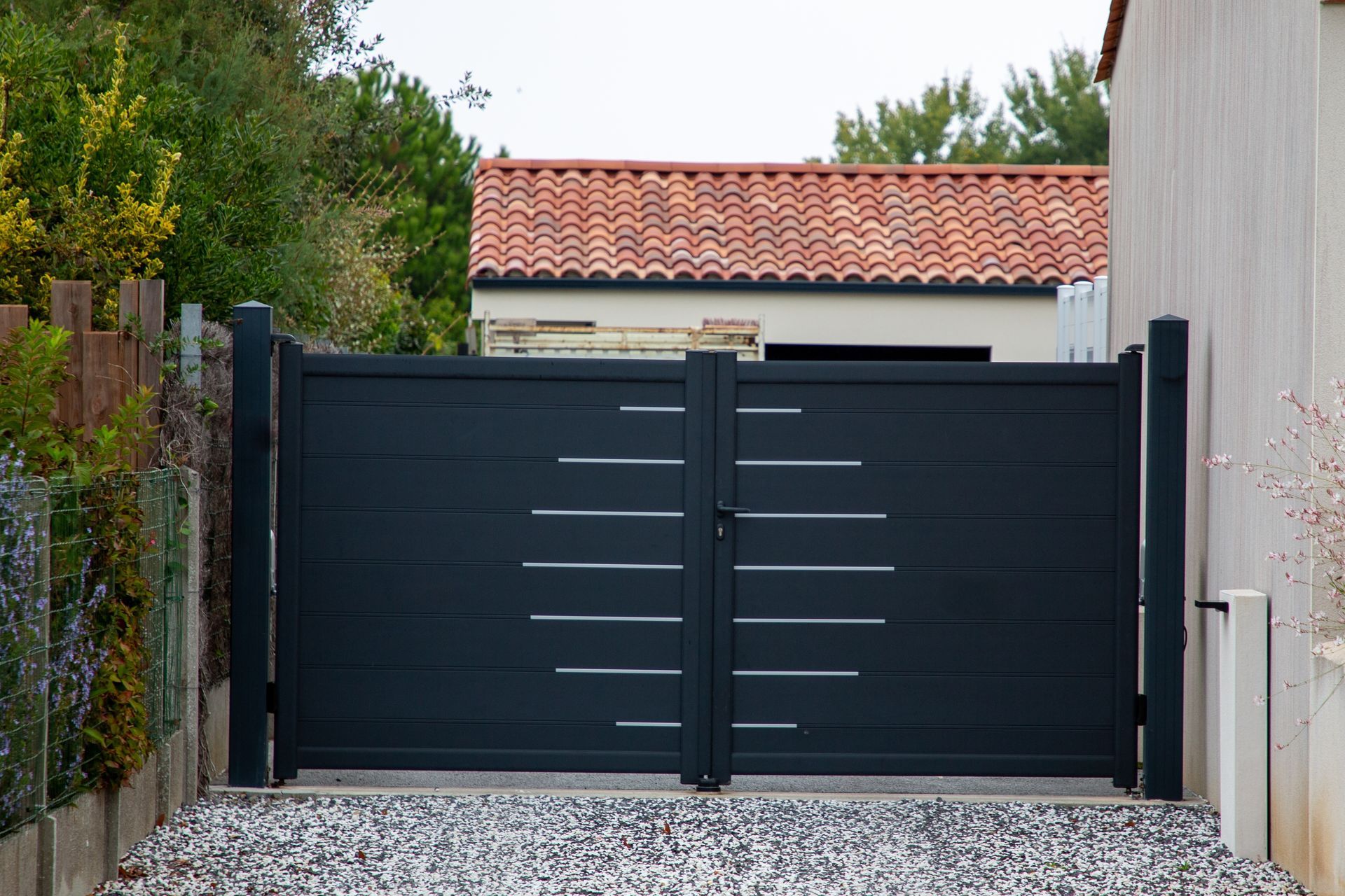 A black gate is sitting in front of a house.
