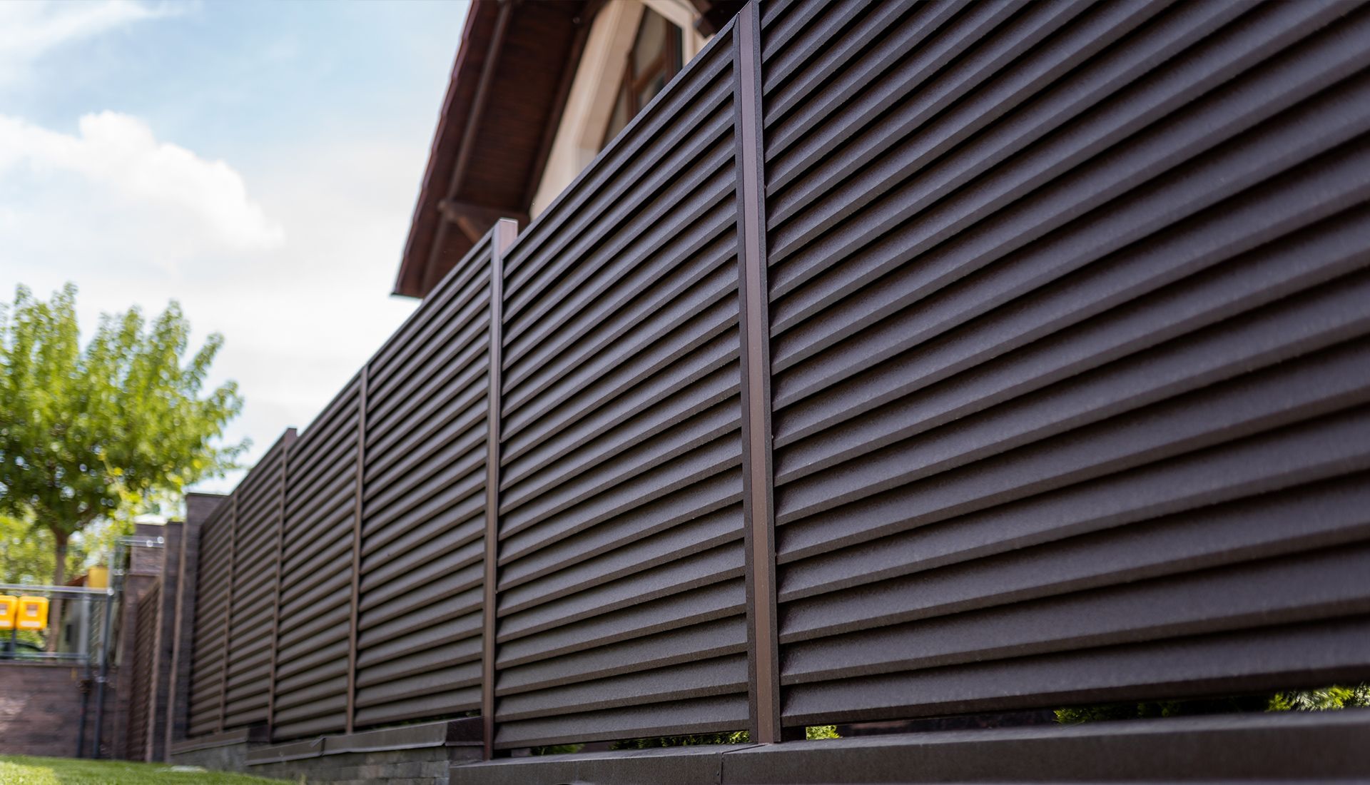 A close up of a brown fence in front of a house.