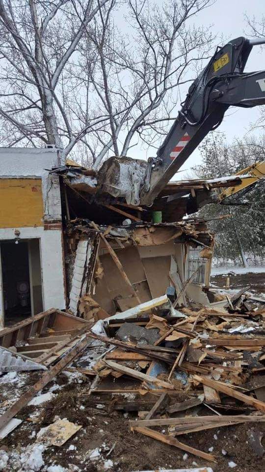 A house is being demolished by a crane.
