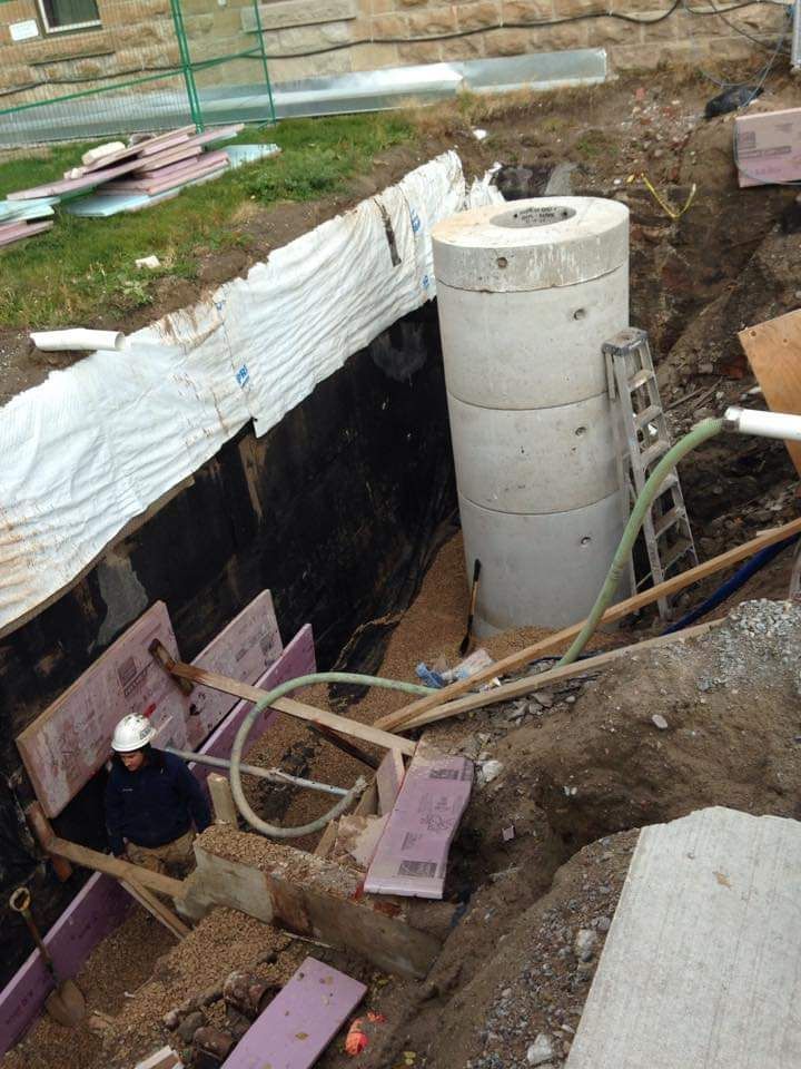 A large concrete cylinder is sitting in the middle of a construction site.